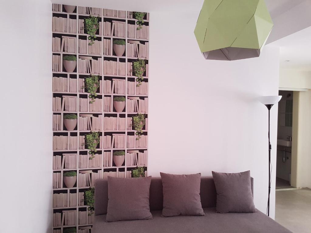 a living room with a couch and a wall with plants at Casa Io - Goraz in Mindelo