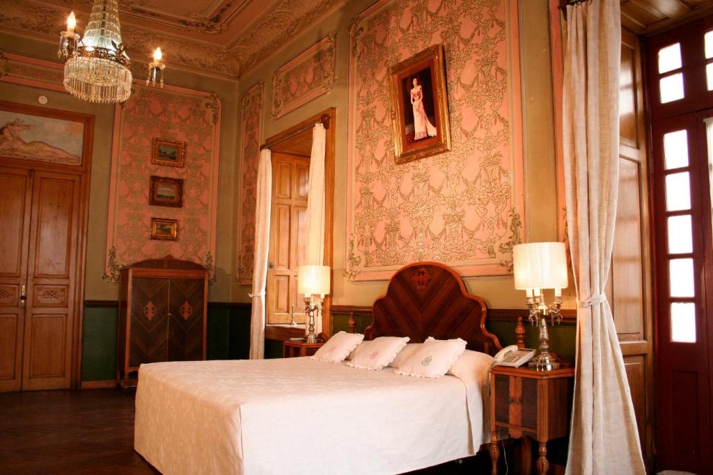 a bedroom with a bed and a chandelier at Hotel Boutique Casa de la Palma in Puebla
