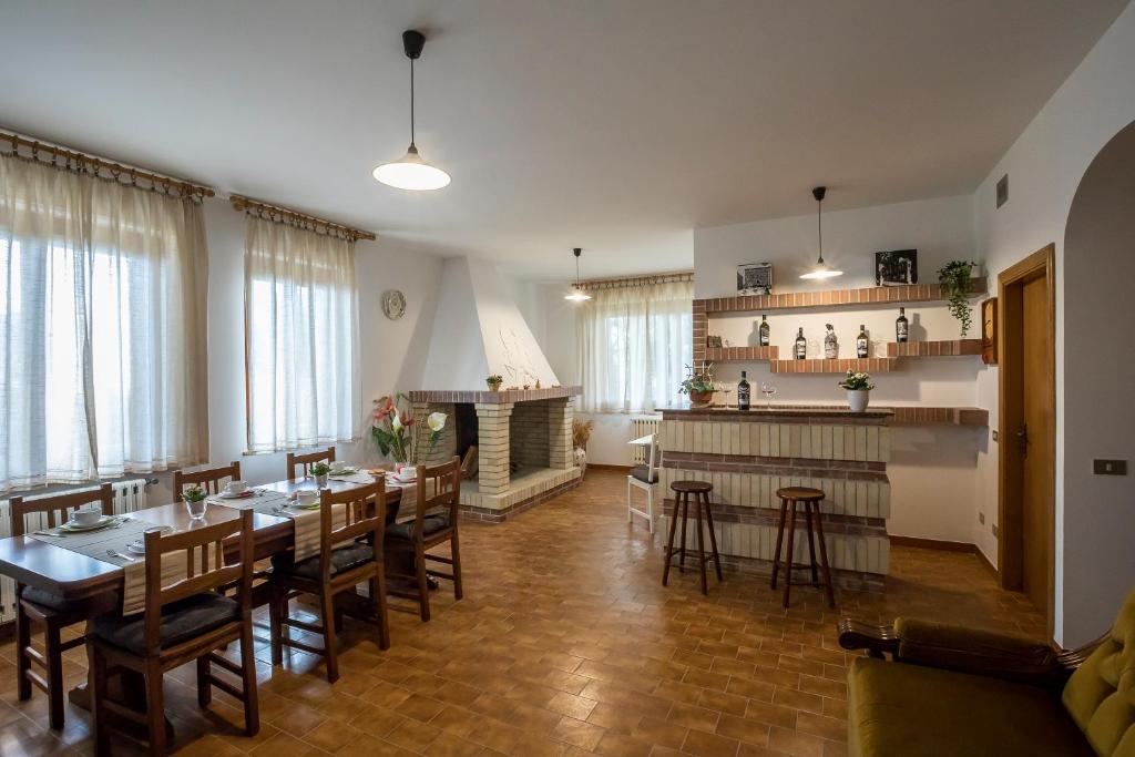 een eetkamer met tafels en stoelen en een keuken bij Zia Regina in Ripatransone