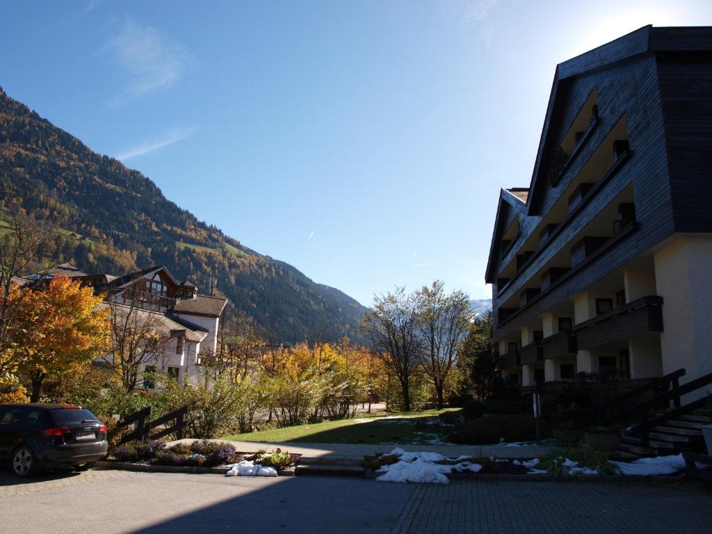a building next to a street with a mountain at Kurpark Appartements in Bad Hofgastein