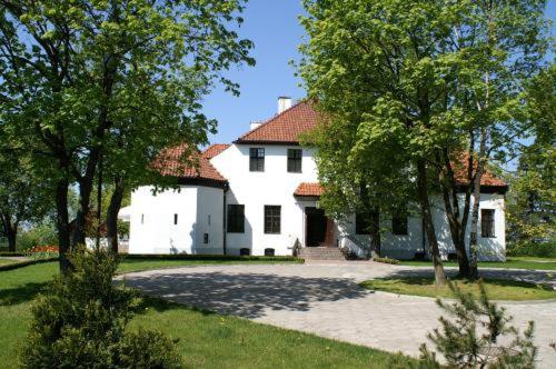 une grande maison blanche avec un toit rouge dans l'établissement Biały Dwór, à Kwidzyn