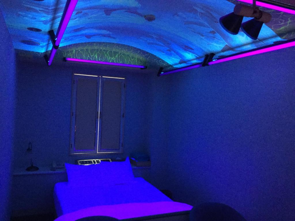 a blue room with a bed with purple lights at Dear Place(Adult Only) in Osaka
