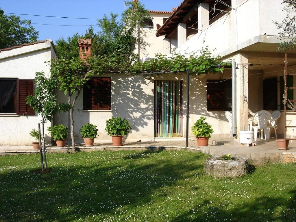 a white house with plants on the side of it at Medulin Apartment 12 in Medulin