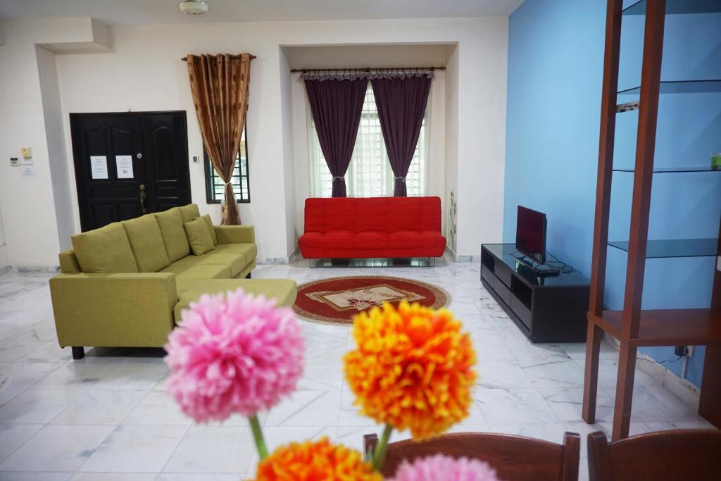 un soggiorno con divano e sedia rossa di Warisan Indah Homestay KLIA 2 a Kampong Melot