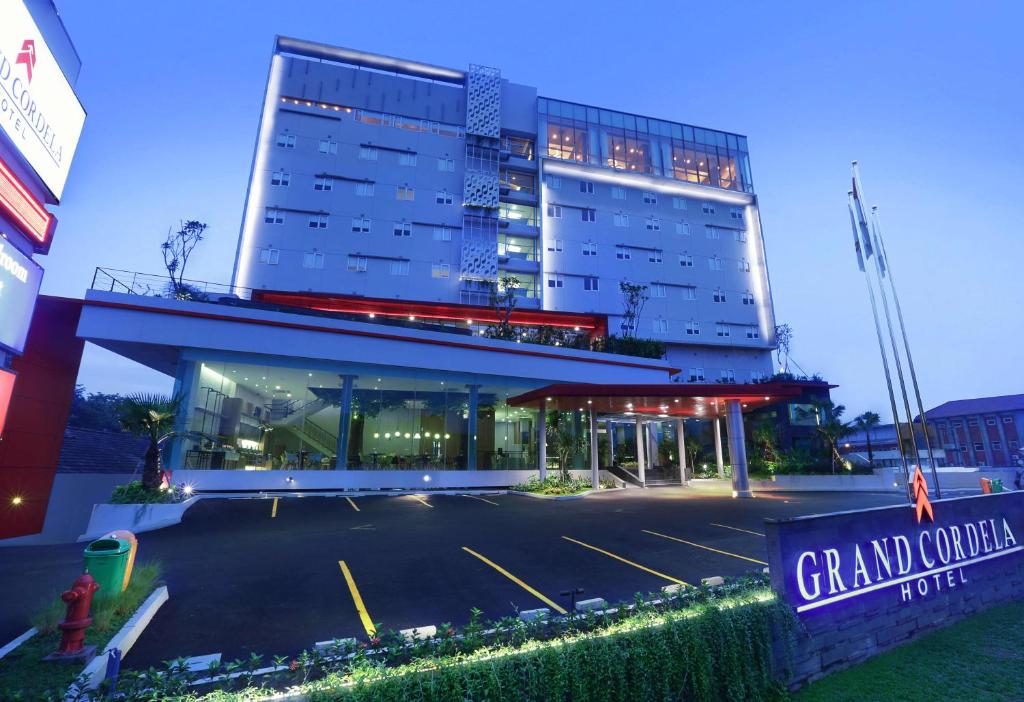 a building with a parking lot in front of it at Grand Cordela Hotel Bandung in Bandung