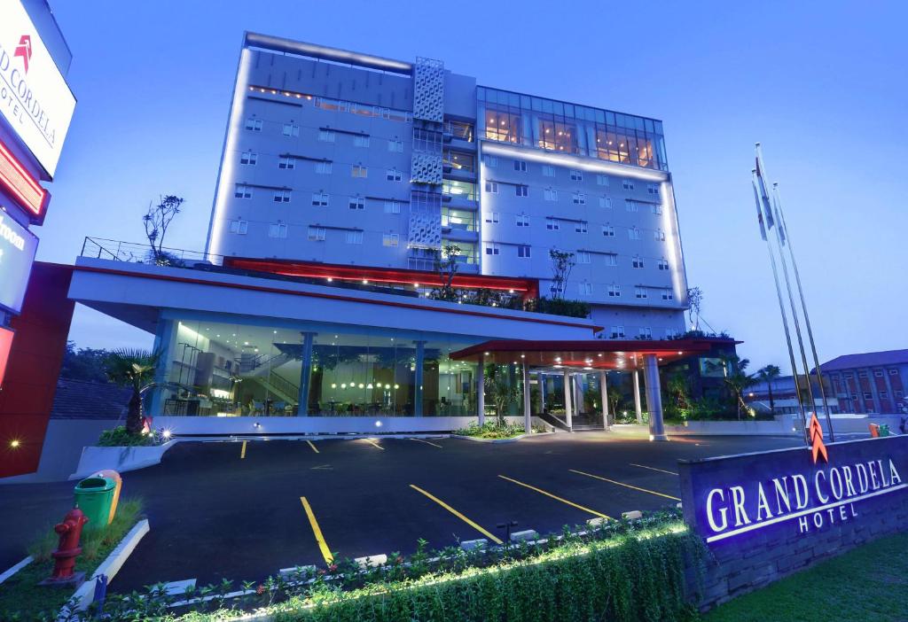 ein Gebäude mit einem Parkplatz davor in der Unterkunft Grand Cordela Hotel Bandung in Bandung