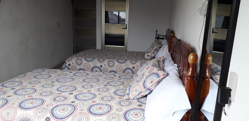 a bedroom with a bed with a wooden headboard and pillows at Hotel Posada Sernichari in Cuetzalán del Progreso