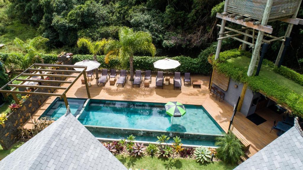 uma vista superior para uma piscina com cadeiras e guarda-sóis em Village do Luz em Barra de Ibiraquera