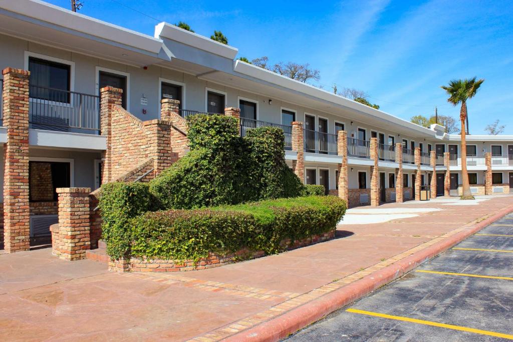 un edificio con un arbusto delante de él en Studio 6-Houston, TX - East, en Houston