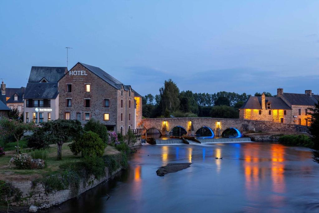 rzeka w mieście z mostem i budynkami w obiekcie Best Western Le Moulin de Ducey w mieście Ducey