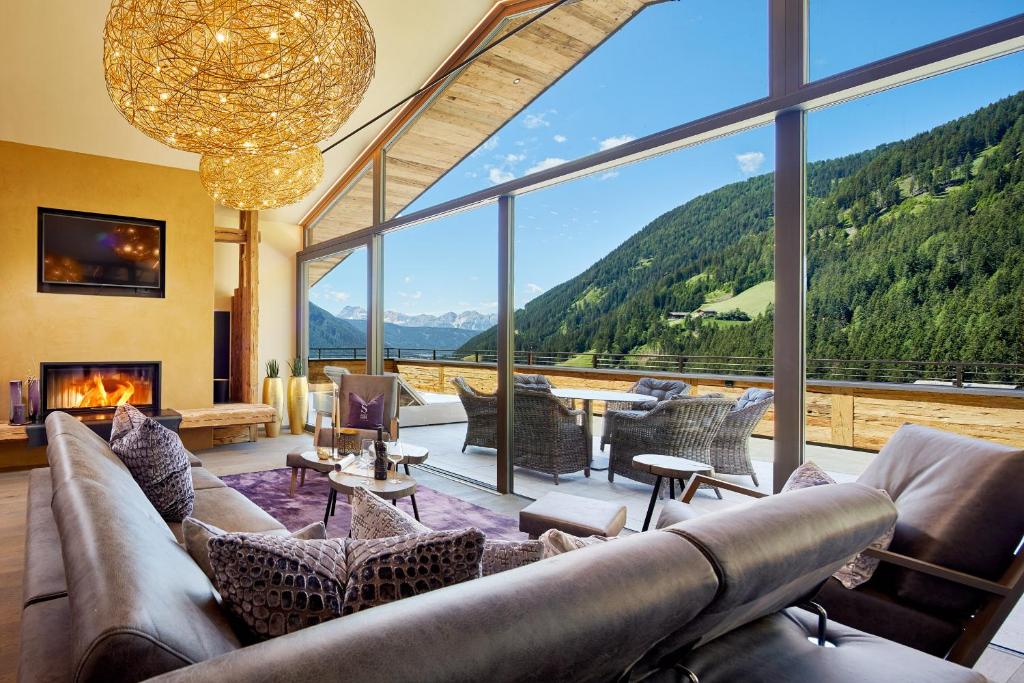 a living room with a couch and a large window at Chalet SALENA luxury lodge in Santa Maddalena in Casies