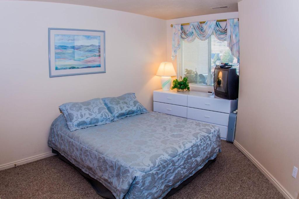 a bedroom with a bed and a tv in it at Harbor Village Pool Building Condo 104 in Garden City