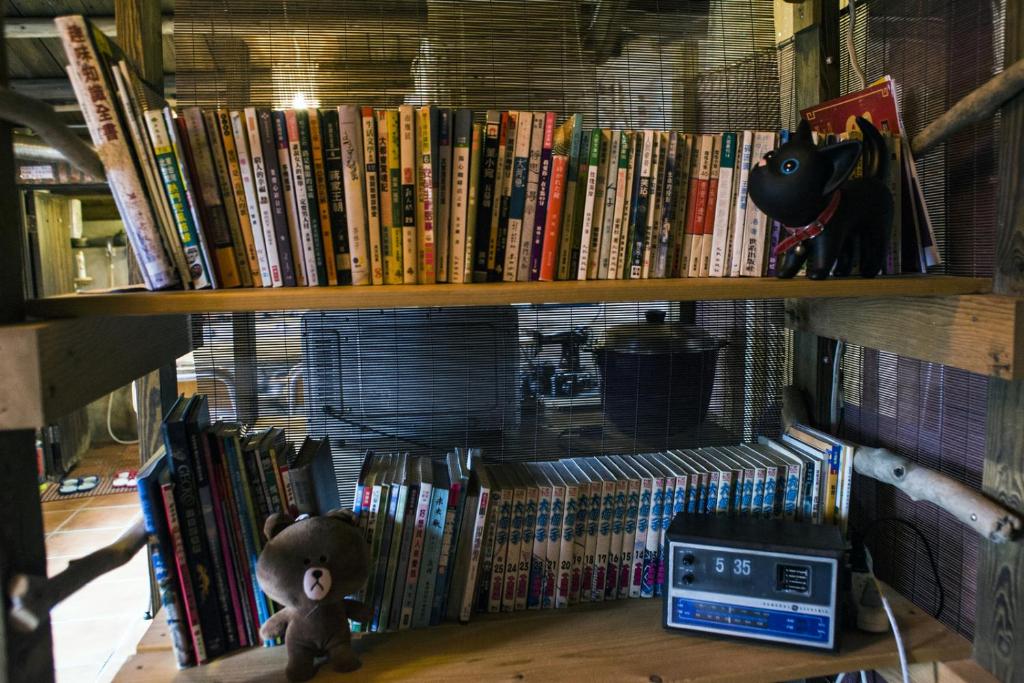 a book shelf full of books with a teddy bear at Shabby Home 28 in Jiufen