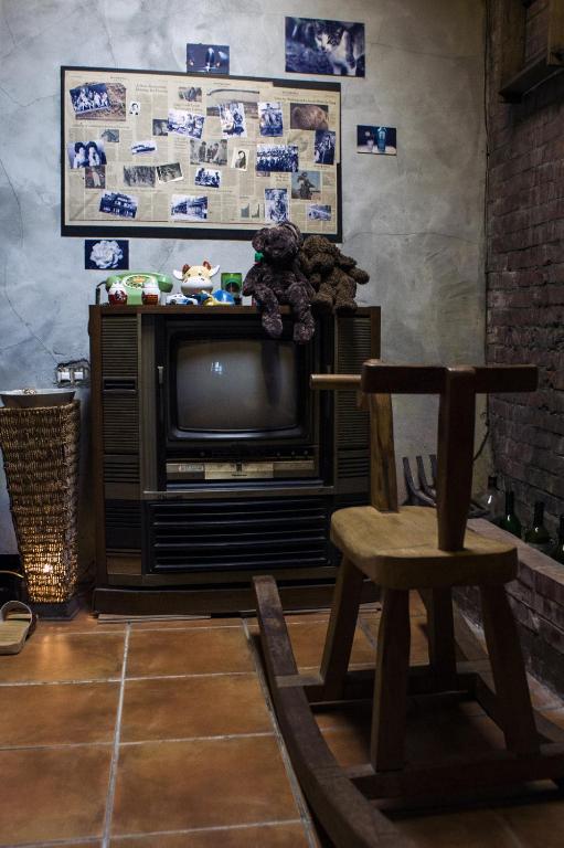 a living room with a tv and a wooden chair at Shabby Home 28 in Jiufen