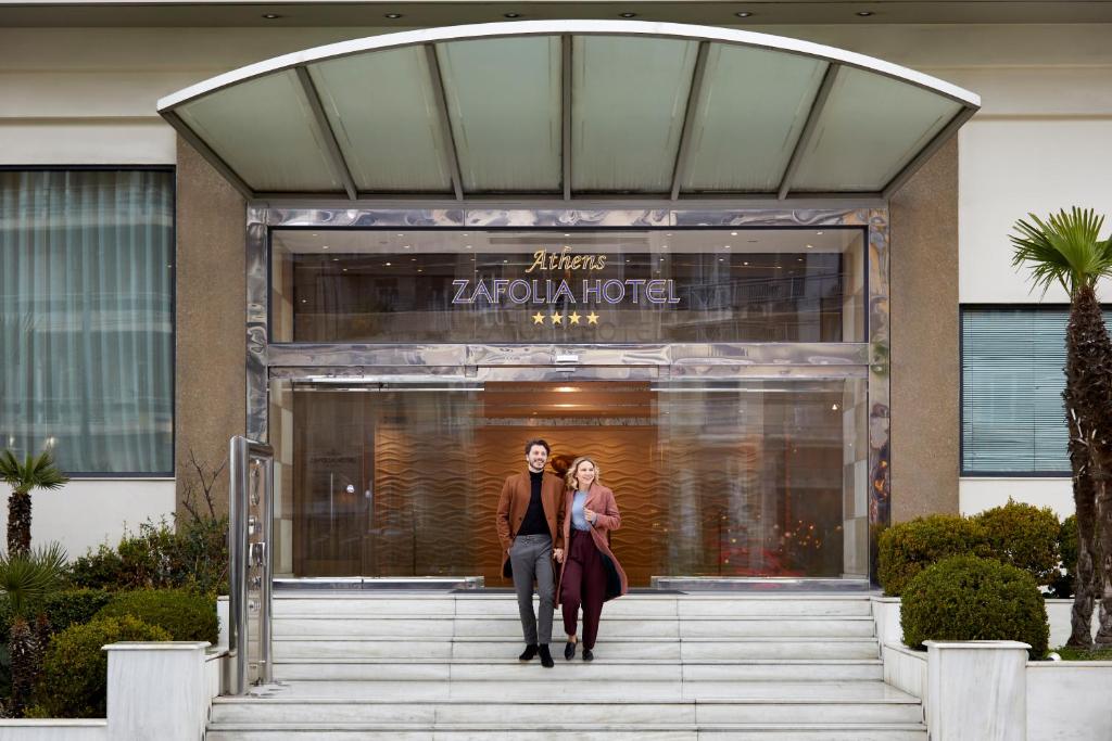 two people walking in front of a zocalo building at Athens Zafolia Hotel in Athens