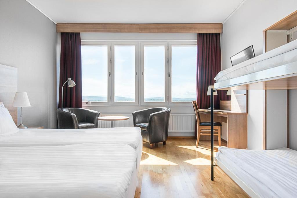 Habitación de hotel con 2 camas, escritorio y sillas en Quality Hotel Bodensia, en Boden