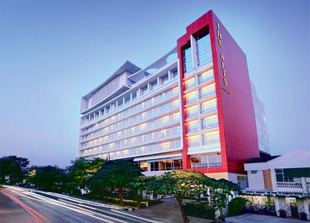 ein großes rotes Hotel mit einer Straße davor in der Unterkunft The Alts Hotel in Palembang
