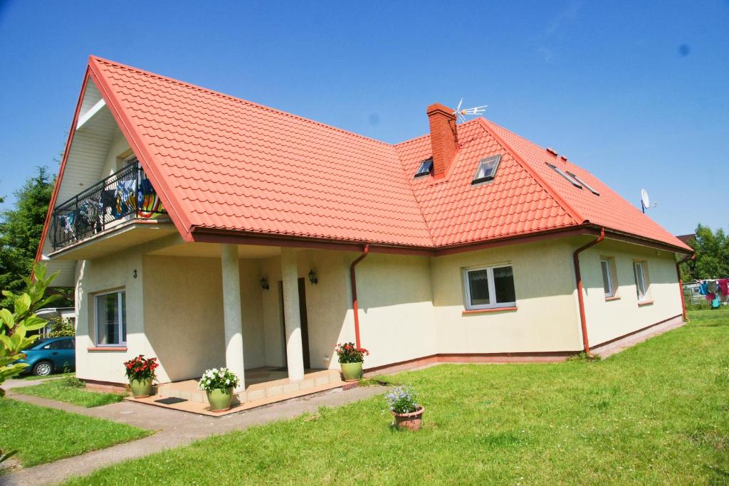 dom z czerwonym dachem i dziedzińcem w obiekcie Prezydencja w mieście Białogóra