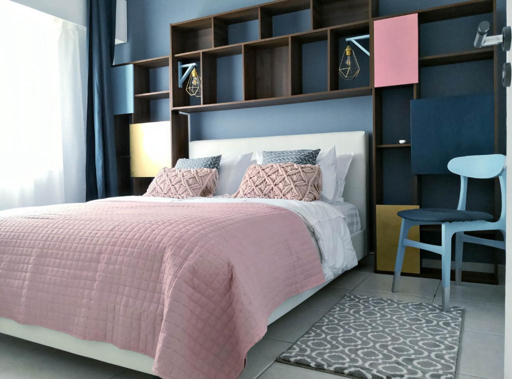 a bedroom with a pink bed and a chair at Cozy Getaway in Nicosia in Yukarı Lakatamya