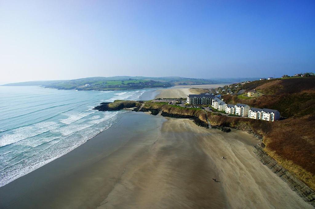 an aerial view of a beach with buildings and the ocean at Inchydoney Island Lodge & Spa in Clonakilty