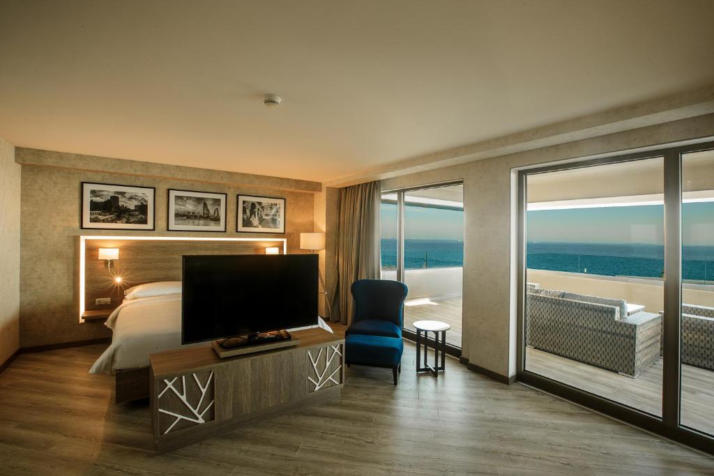 a hotel room with a bed and a television and a balcony at Radisson Hotel Baku in Baku