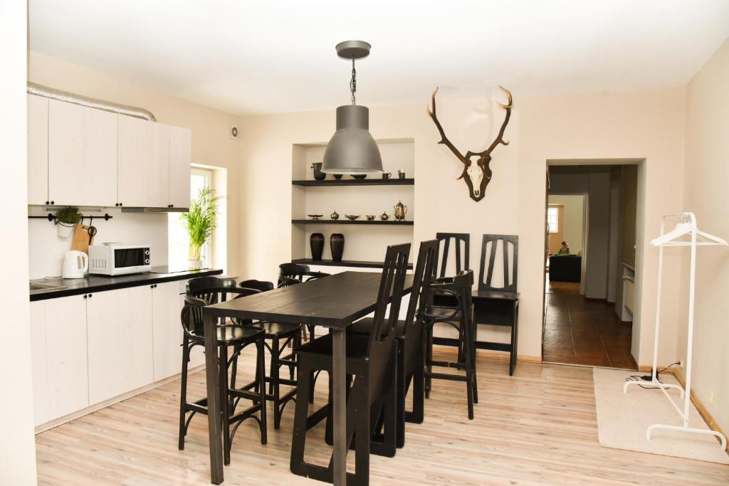 a kitchen and dining room with a black table and chairs at Garden View Home in Mārupe