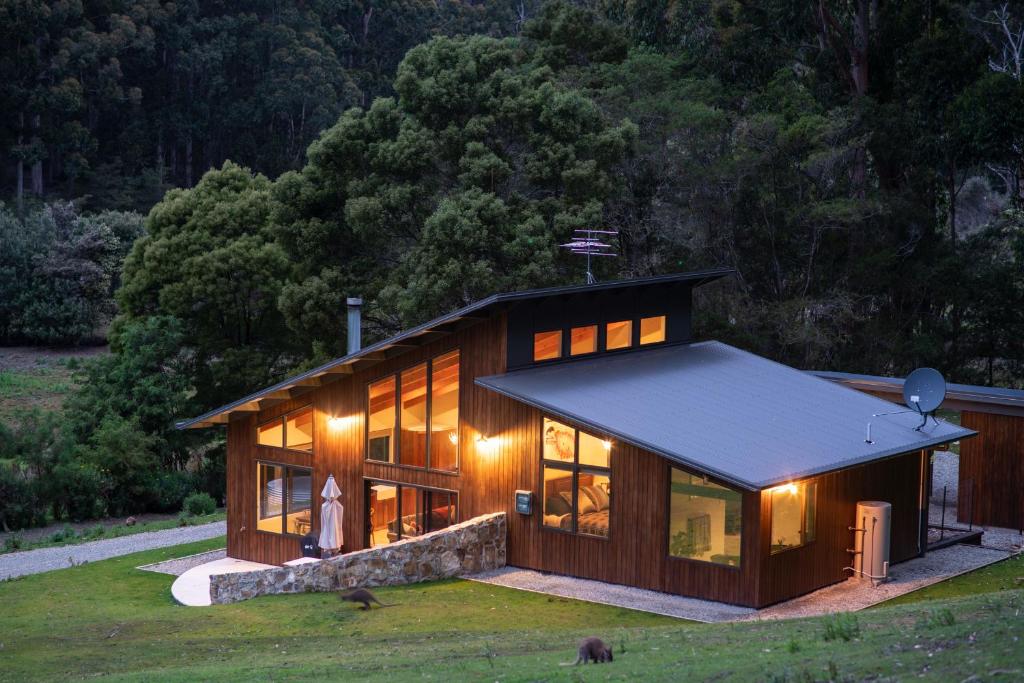 una gran casa de madera con muchas ventanas en Adventure Bay Retreat Bruny Island, en Adventure Bay