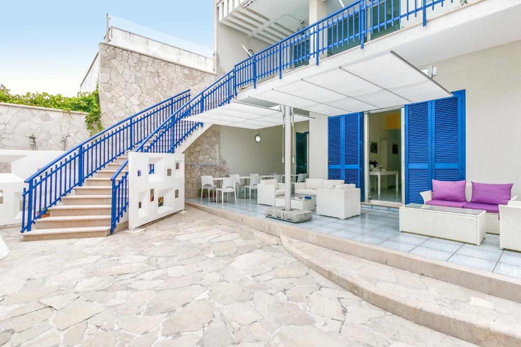 a house with blue and white stairs and a patio at Villa Syrmata by BarbarHouse in Porto Cesareo