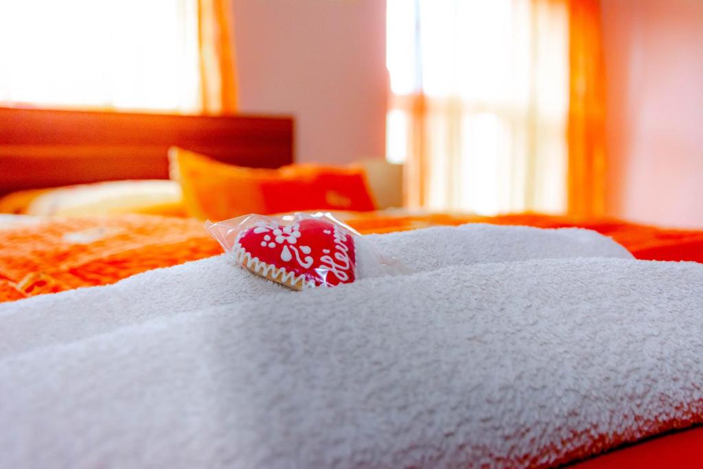 ヘーヴィーズにあるHürkecz Apartmanházのベッド上に置いた赤白の歯ブラシ