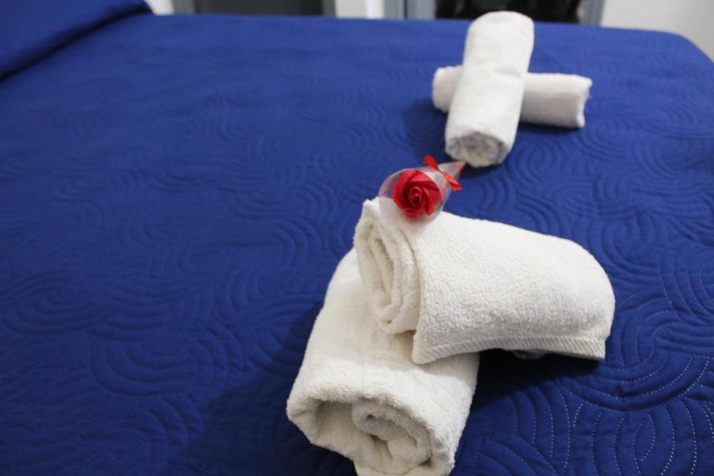 a bed with two towels and a rose on it at Monolocale da Angelo in Castellammare del Golfo