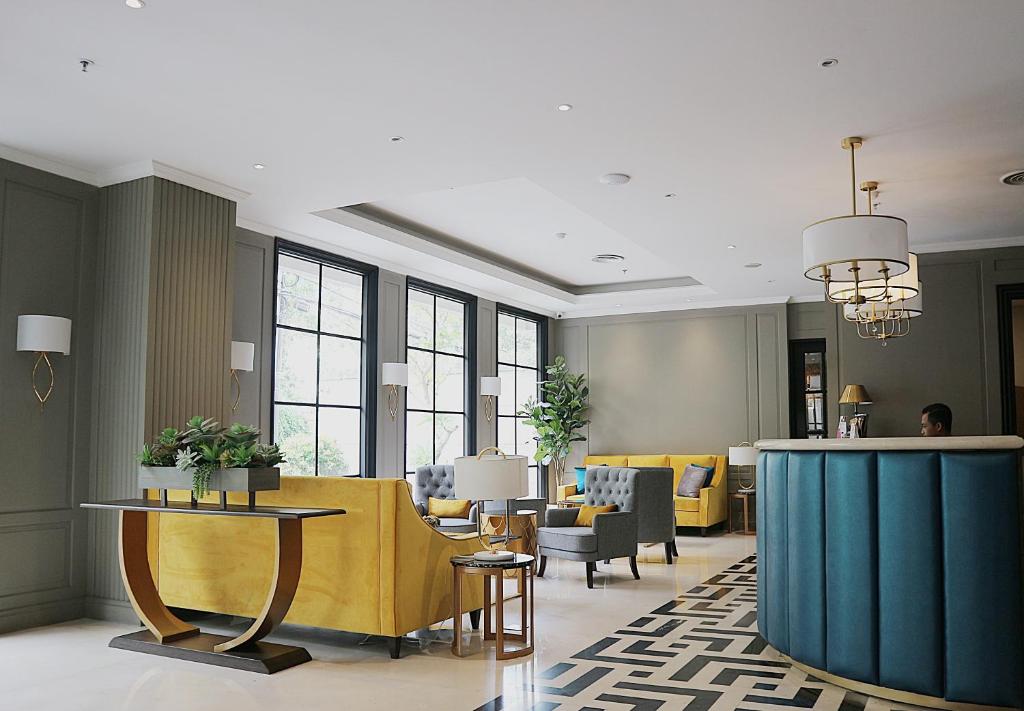 a lobby with a waiting area with chairs and tables at Hotel Shalva Jakarta in Jakarta