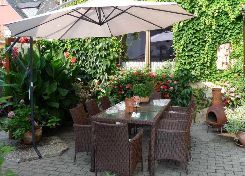 un tavolo e sedie con ombrellone in giardino di Gästehaus Kön a Zeltingen-Rachtig