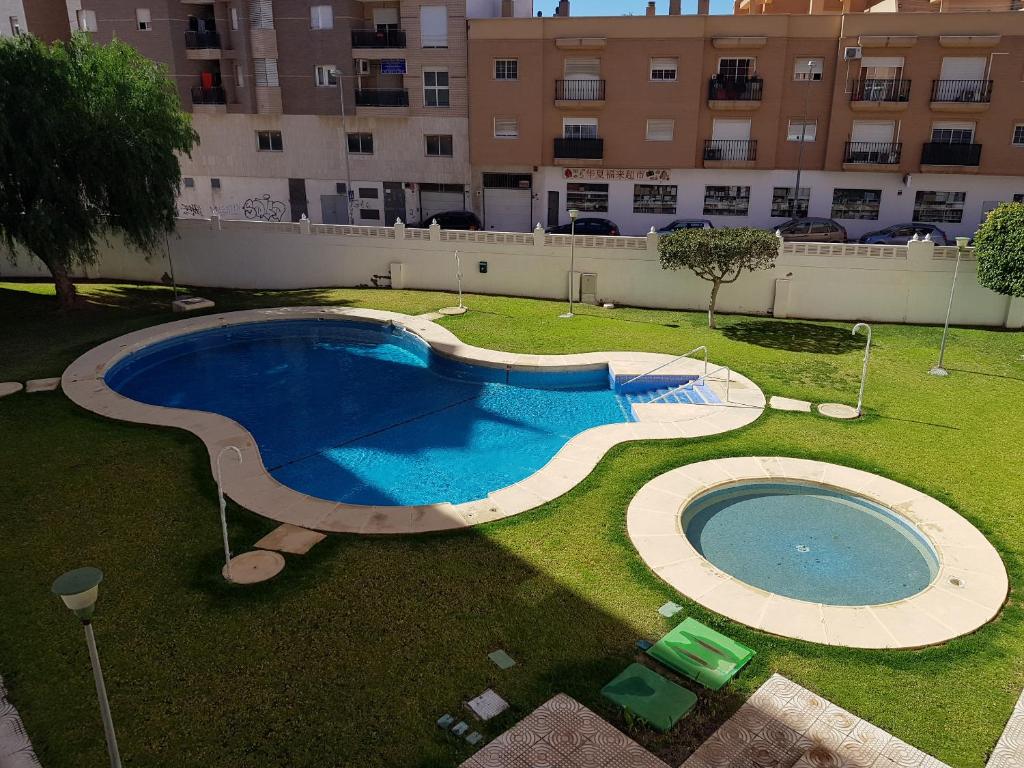 een groot zwembad in het midden van een tuin bij Apartamento Aguadulce Moreno in Roquetas de Mar