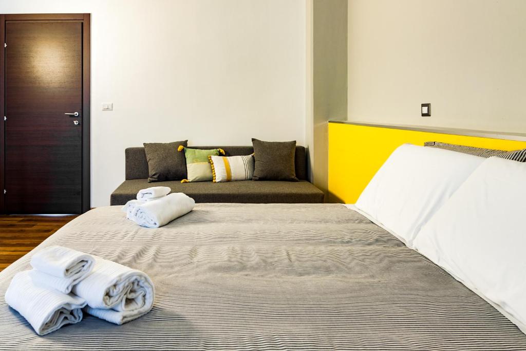 a bedroom with two towels on a bed with a couch at TRAVEL STATION Bedandbreakfast in Bari