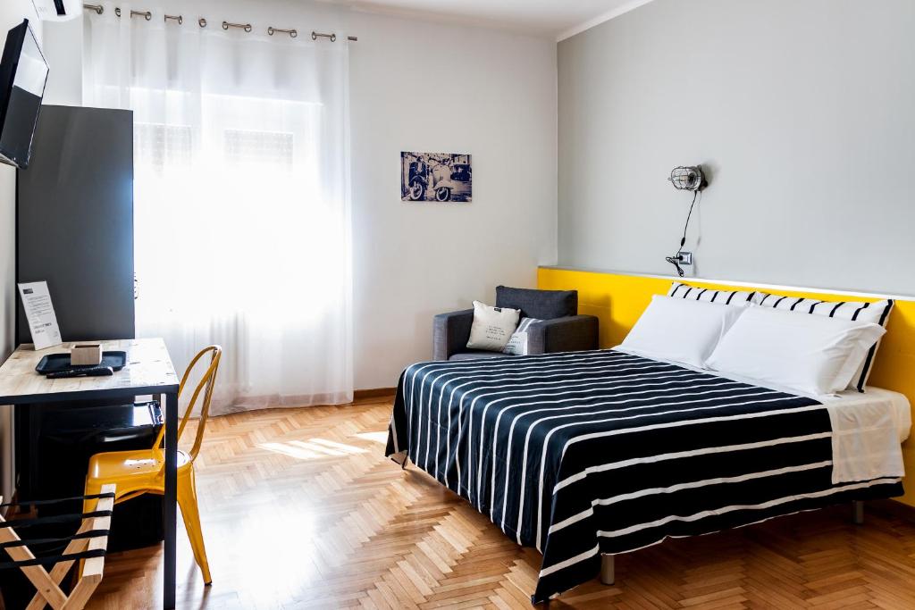 a bedroom with a black and white striped bed and a desk at TRAVEL STATION Bedandbreakfast in Bari