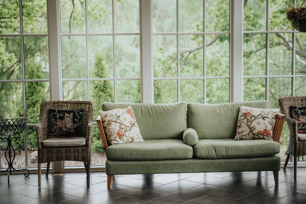 a green couch in front of a large window at Balingsholm in Huddinge