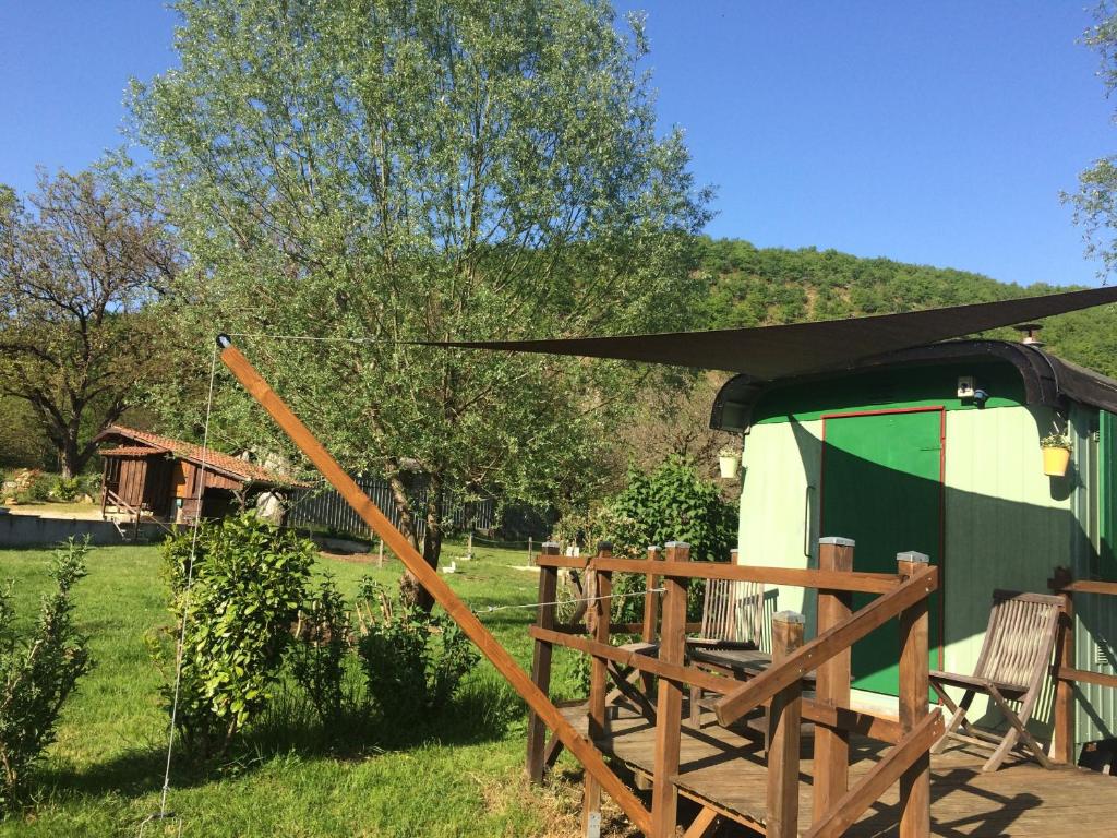 awning over a yurt with a table and chairs in the grass at pipowagen Blagour midden in de natuur in Lachapelle-Auzac