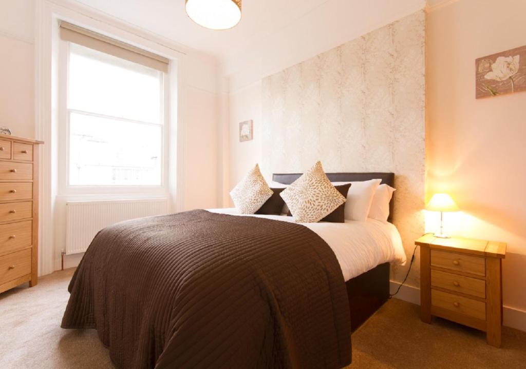 a bedroom with a large bed and a window at Thorne Lodge in Eastbourne