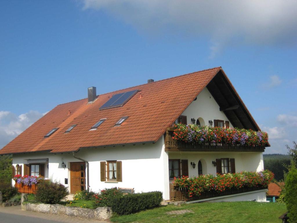 uma casa branca com um telhado vermelho em Ferienwohnungen Haberberger em Pottenstein