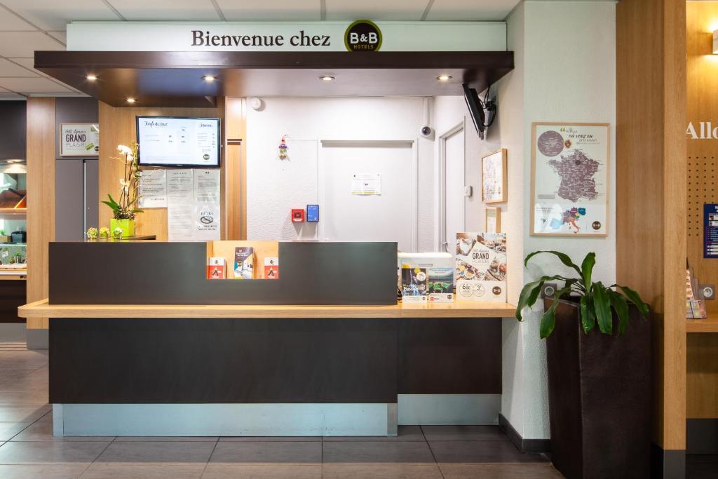 a restaurant with a counter with a sign above it at B&B HOTEL Paris Le Bourget in Le Bourget