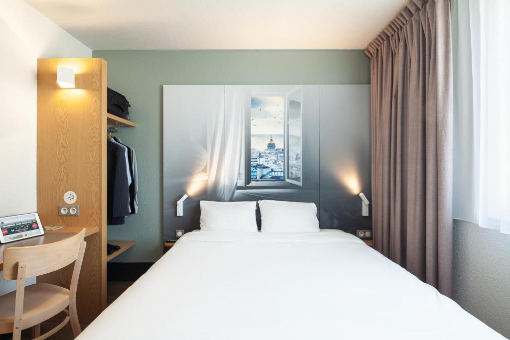 a bedroom with a bed and a desk and a bed at B&B HOTEL Paris Le Bourget in Le Bourget