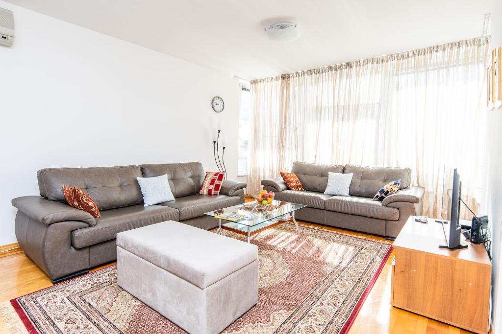a living room with two couches and a tv at Modern 2BDR apartment in the center- FREE PARKING in Sarajevo