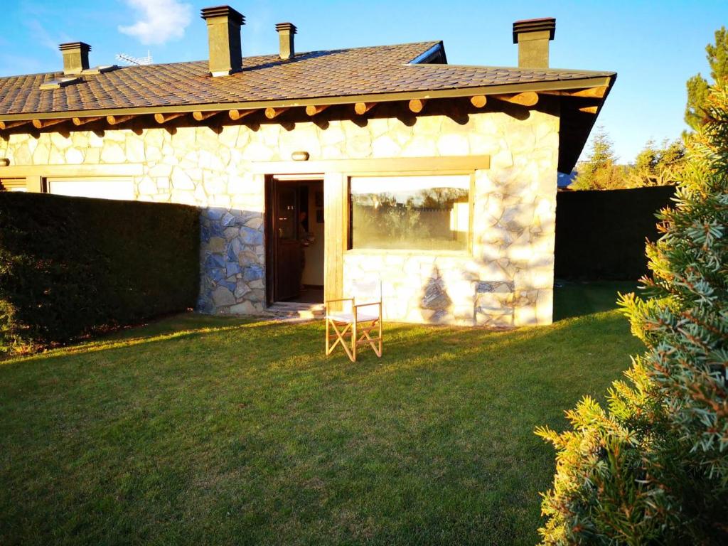 una pequeña casa de piedra con una silla en el patio en Casa acogedora en Santa Leocadia, en Sainte-Léocadie