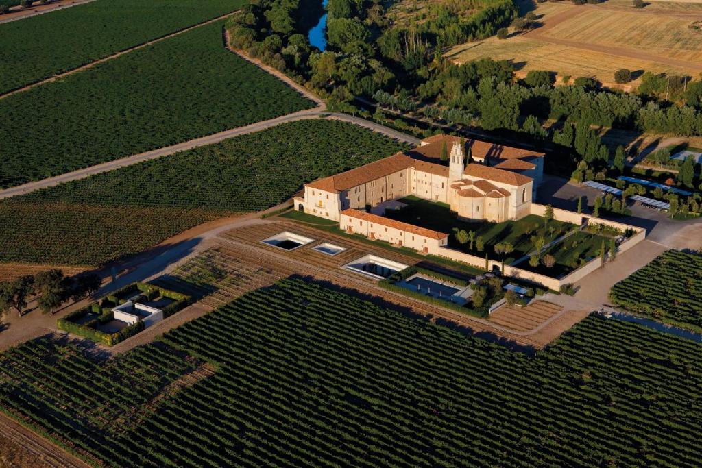 eine Luftansicht eines großen Hauses mit einem Feld in der Unterkunft Abadia Retuerta LeDomaine in Sardoncillo