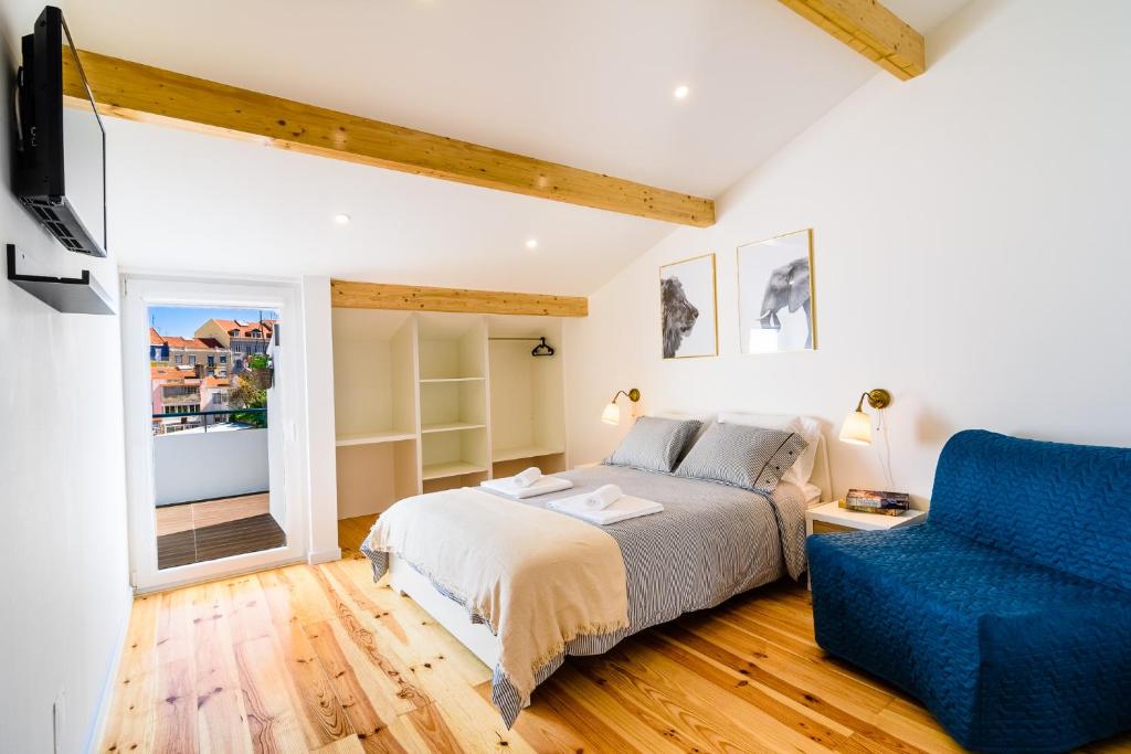1 dormitorio con 1 cama y 1 silla azul en In2Lisbon - Kionga Suites, en Lisboa