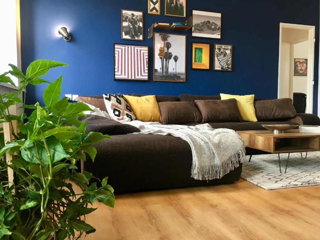 uma sala de estar com um sofá preto e uma parede azul em Blu Apartment in Old Town em Bratislava