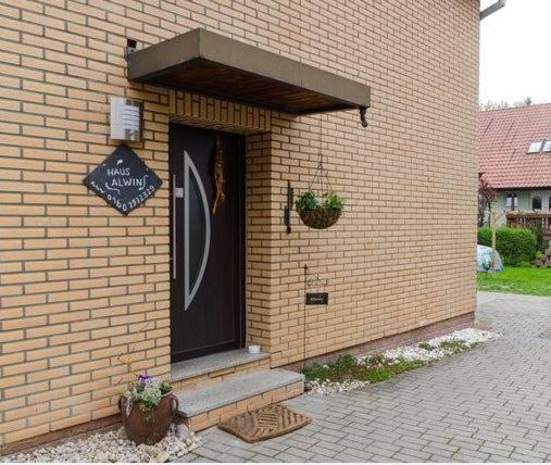 ein Backsteingebäude mit einer schwarzen Tür und einer Treppe in der Unterkunft Ferienwohnungen Siegfried Röder in Erfurt