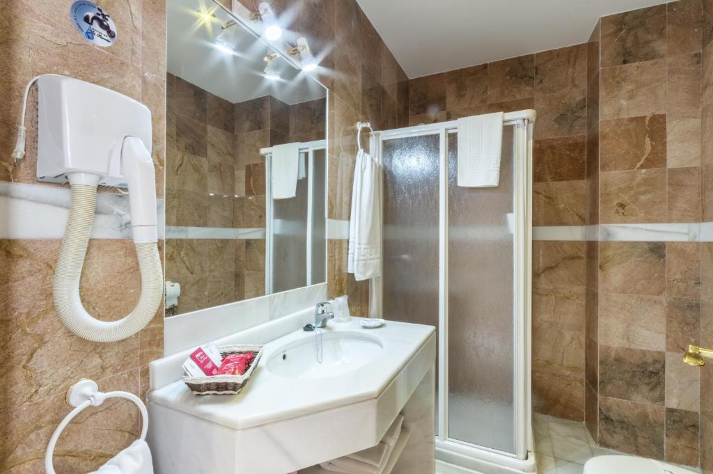 łazienka z umywalką i prysznicem w obiekcie Hotel La Parrita w mieście Rota