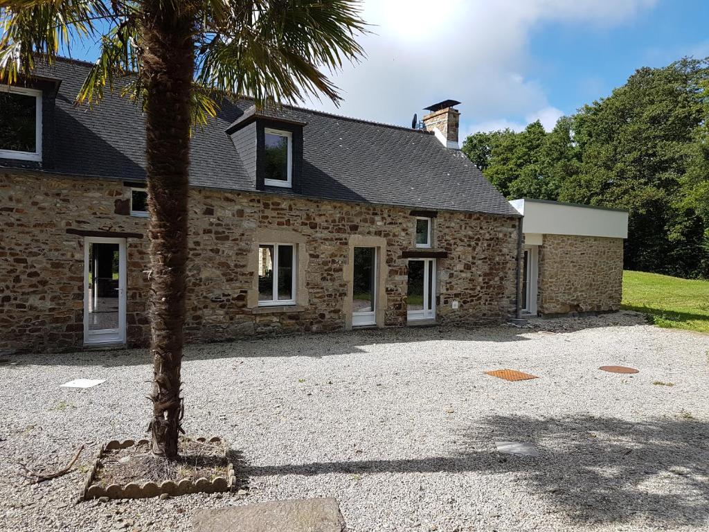 una casa con una palmera delante de ella en La Puisatière en Saint-Pierre-dʼArthéglise