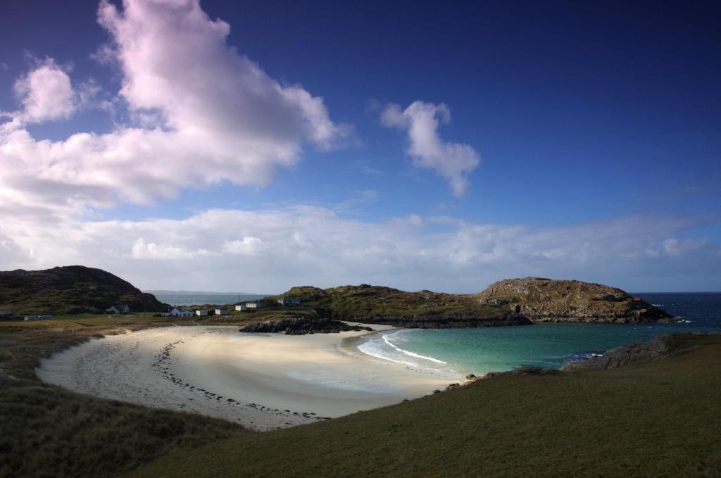 a view of a beach with rocks in the ocean at North Coast 500 Pods in Achmelvich